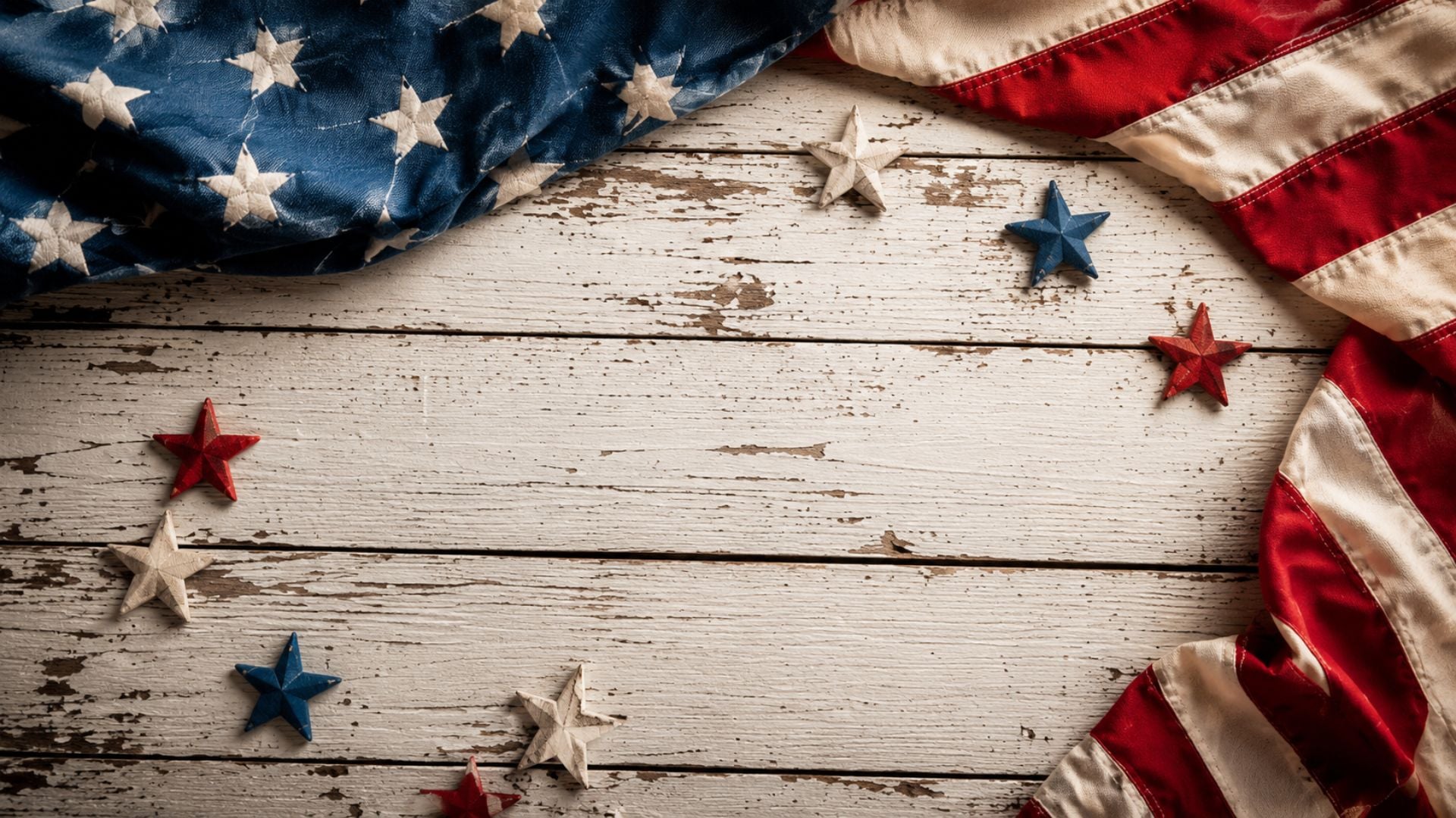 Rustic red, white, and blue desktop wallpaper featuring a vintage American flag and wooden stars on a distressed wood background.