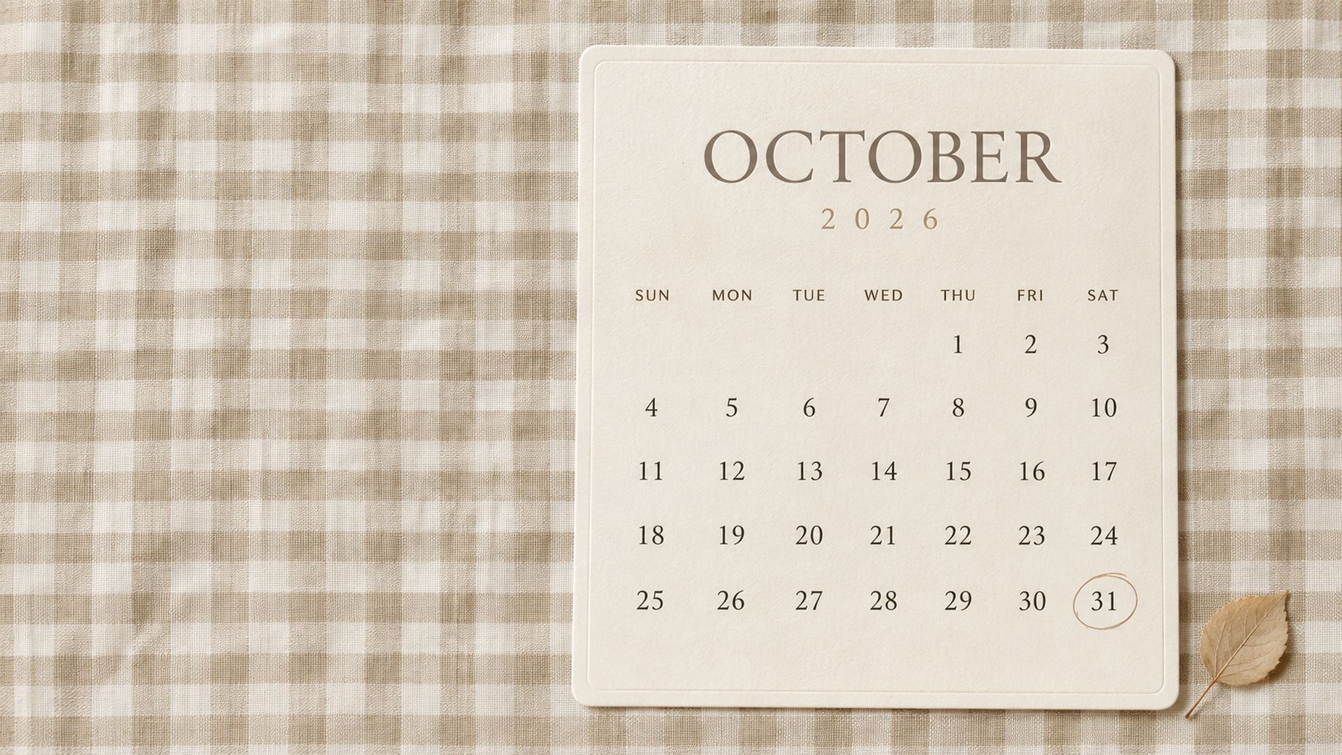 Neutral October 2026 desktop wallpaper with subtle beige gingham, a cream calendar card and simple fall typography.