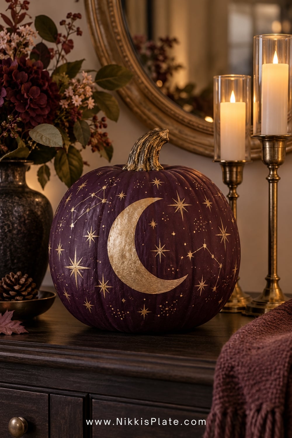 Plum pumpkin painted with gold moons, stars and tiny constellations.