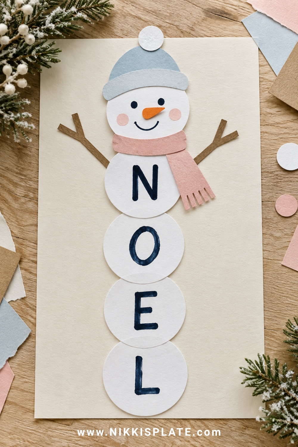 Snowman name craft spelling NOEL with white paper circles, blue hat and blush scarf.