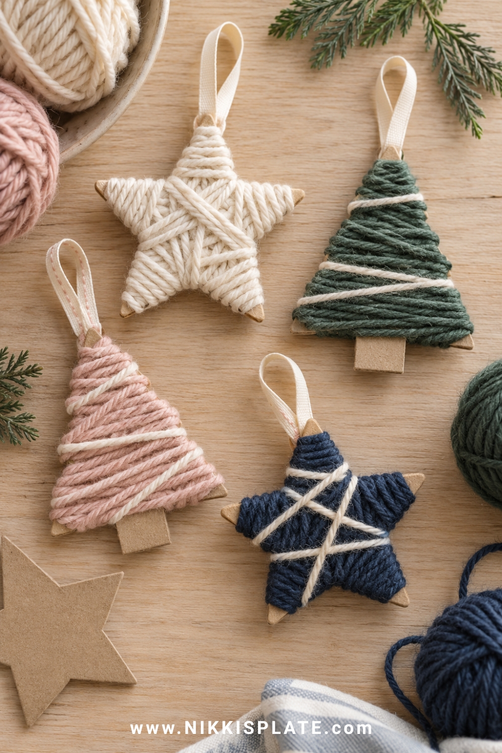 Yarn wrapped cardboard christmas ornaments shaped like stars and trees, using cream, blush, navy and muted green chunky yarn with simple ribbon loops.