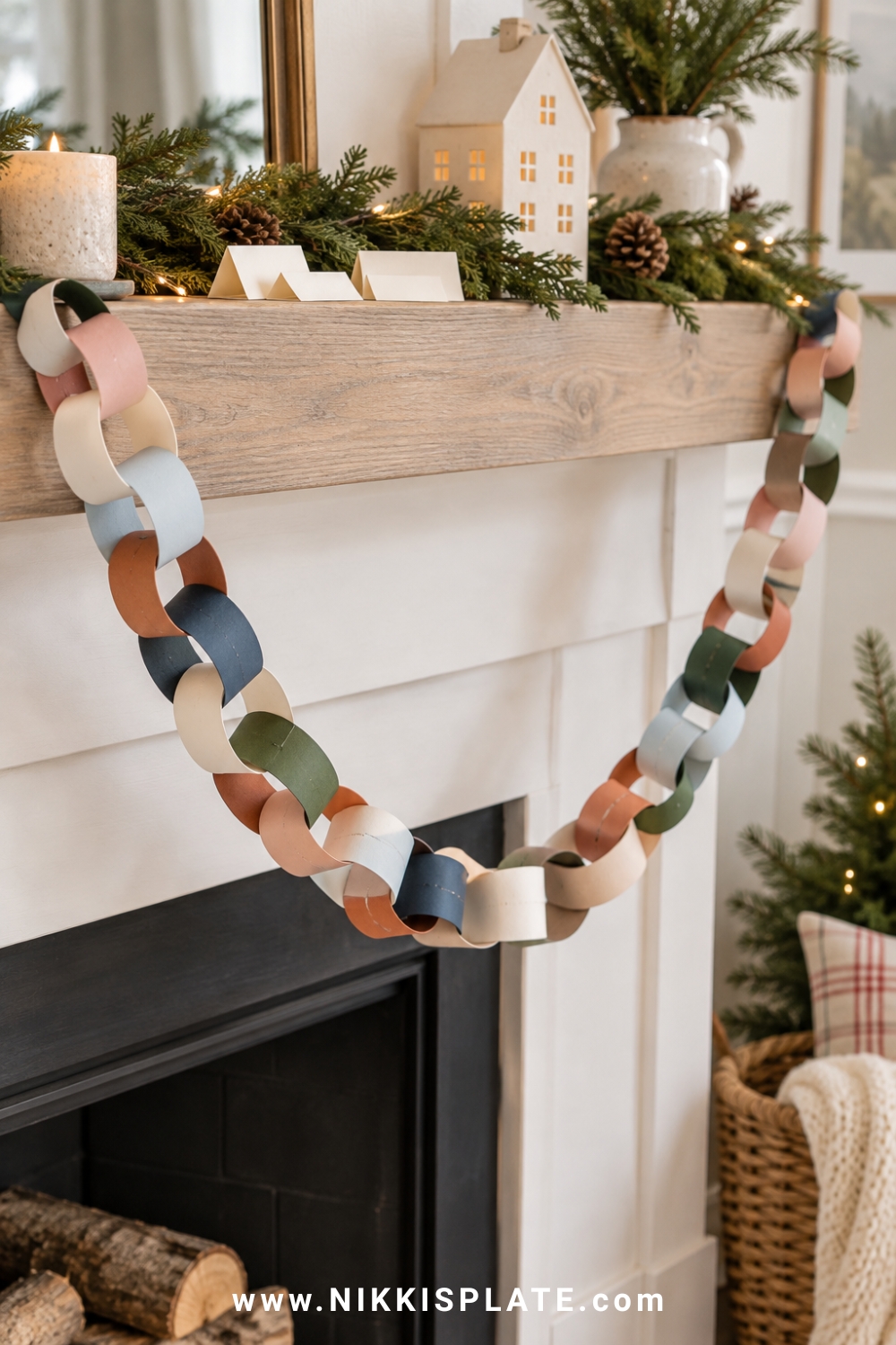 A christmas paper chain countdown in blush, cream, pale blue, rust, navy and muted green hanging from a farmhouse mantel with a few handwritten activity slips.