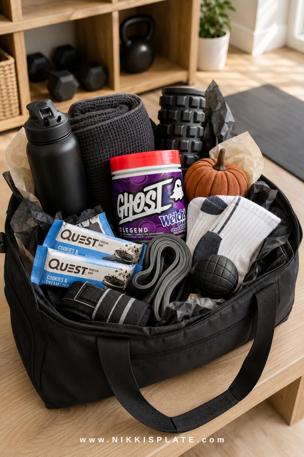 Fitness recovery boo basket for him with a water bottle, resistance bands, massage tools, snacks and fresh socks.