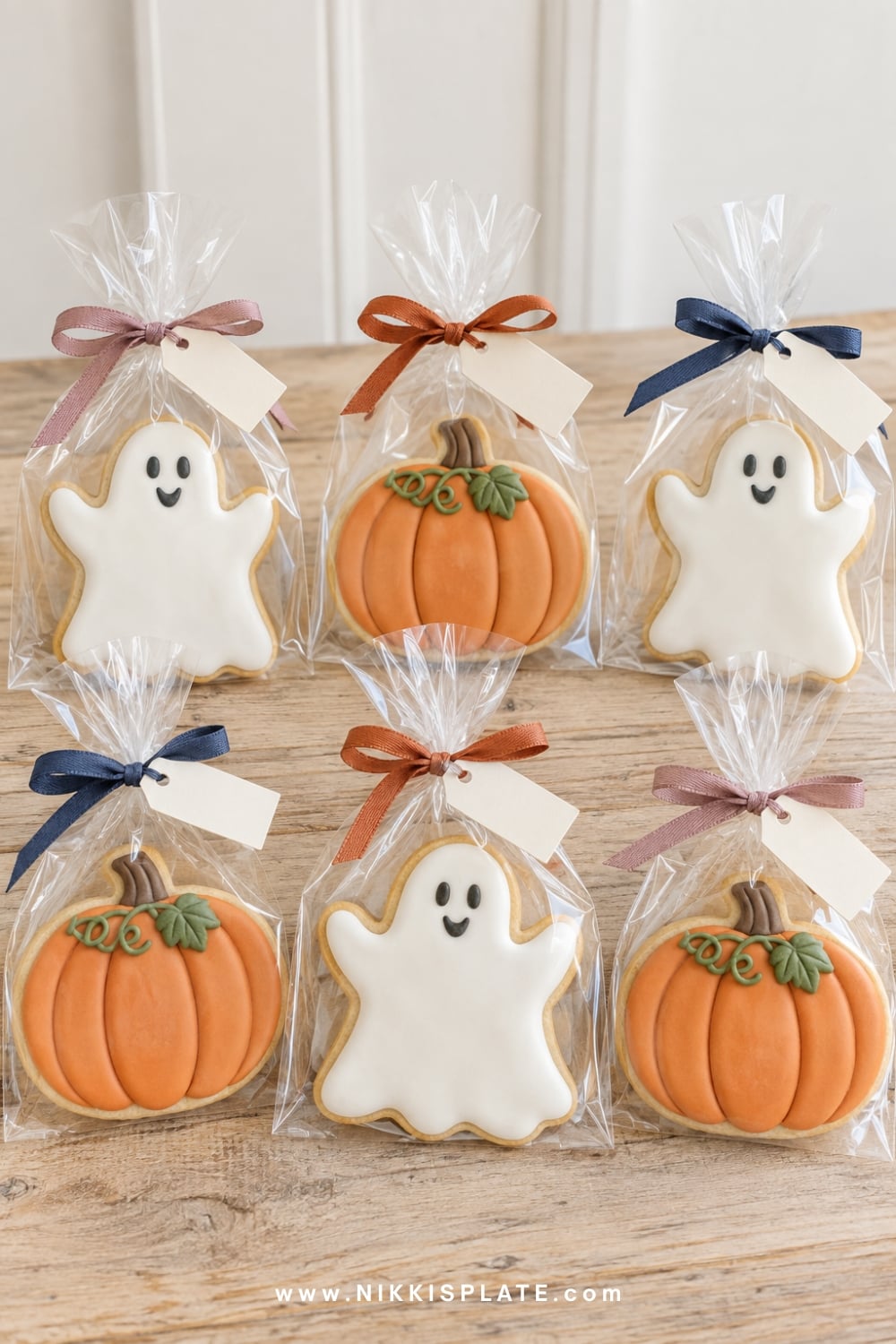 Wrapped Halloween cookies in clear sleeves with ribbon and tags.