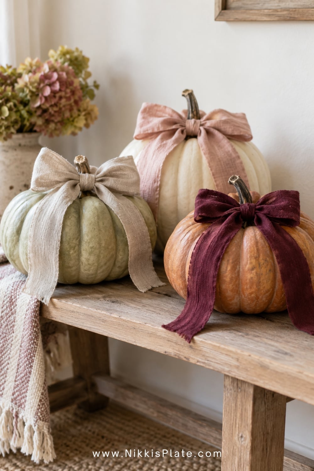 Cream and pale green pumpkins finished with oversized linen bows.