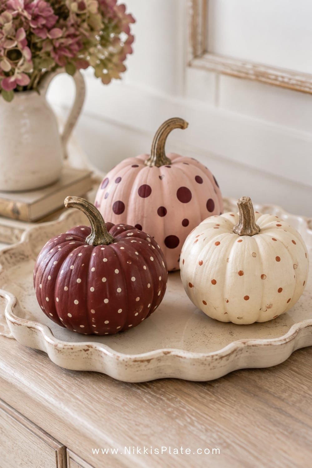 Burgundy, blush and cream pumpkins decorated with painted polka dots.