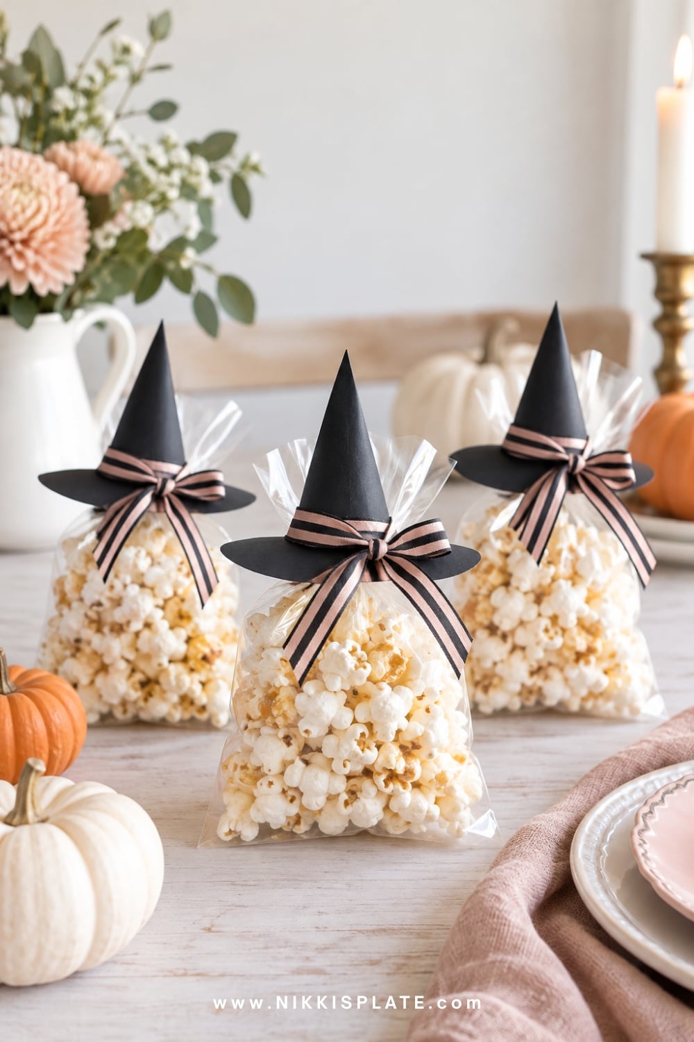 Sealed popcorn snack bags styled with witch-hat toppers and striped ribbon.
