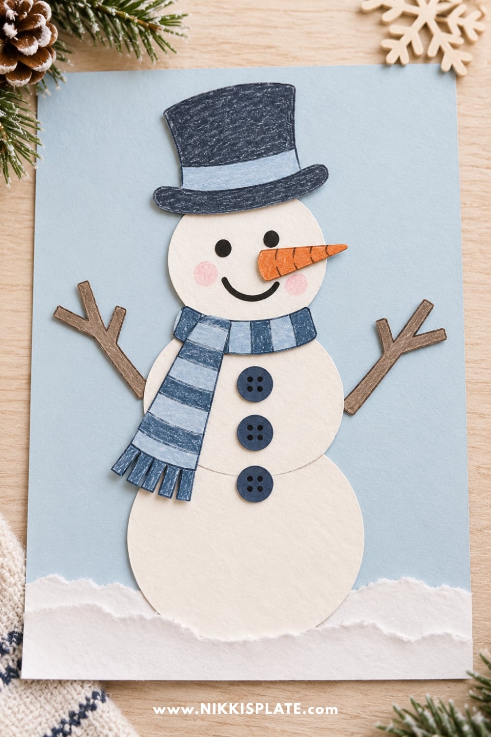 Finished printable snowman craft for kids with a hat, scarf, buttons and paper decorations