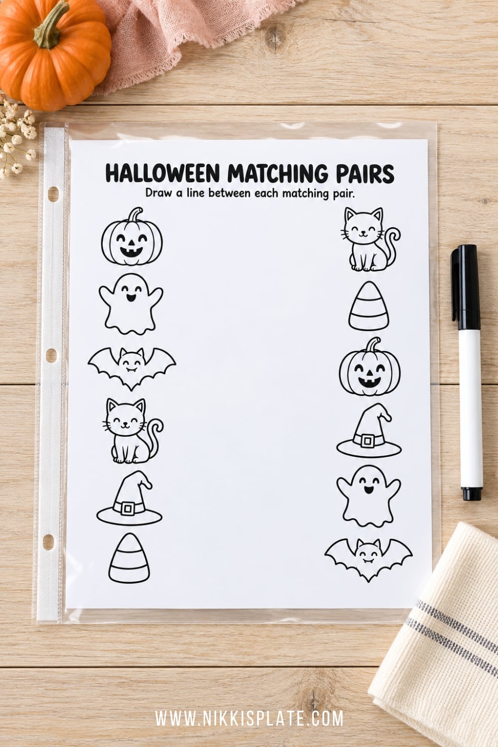 Halloween activity worksheet inside a clear sheet protector with a dry-erase marker.
