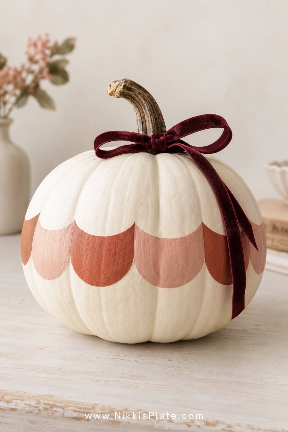 Cream pumpkin decorated with rust and blush painted scallops.