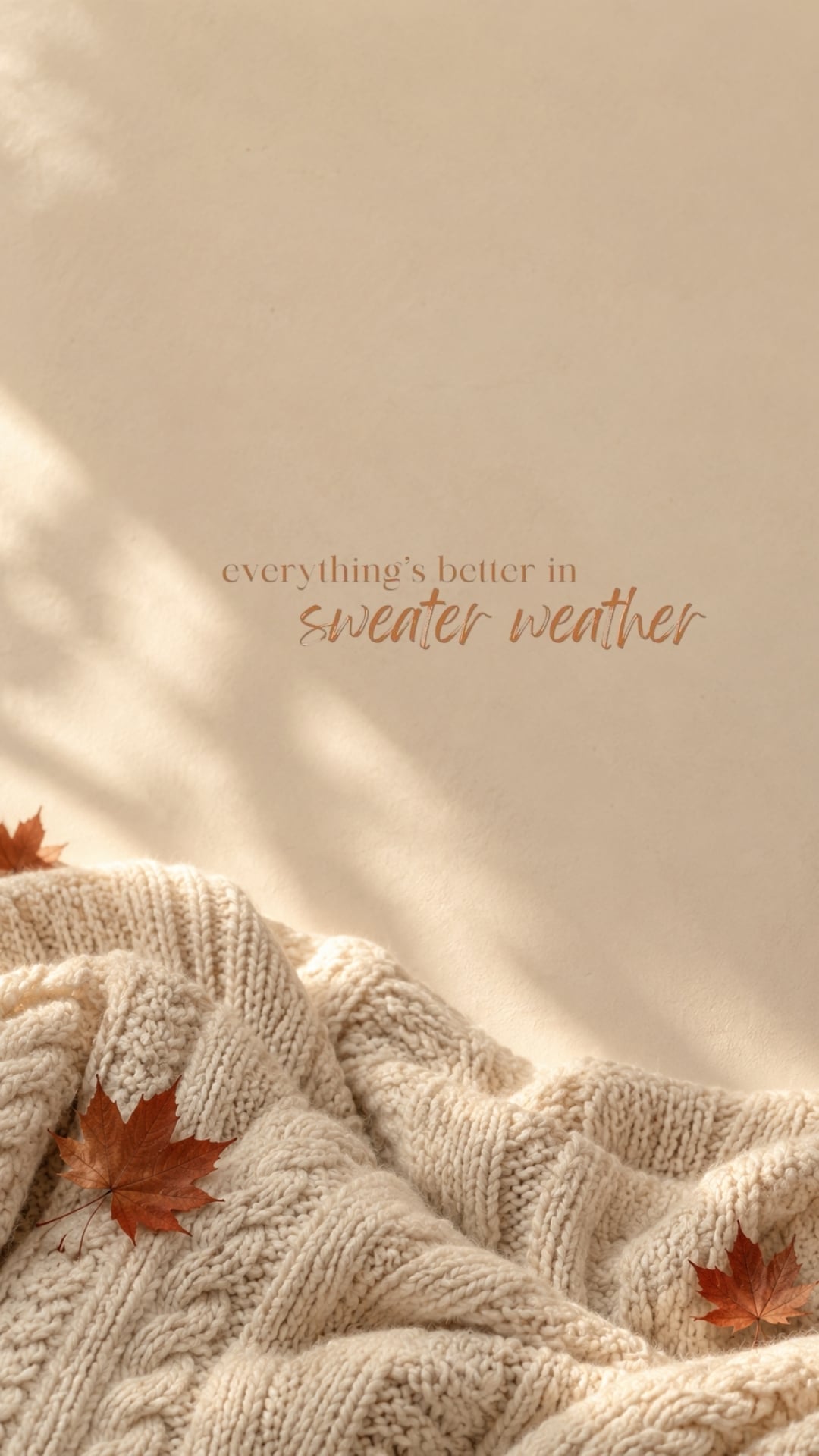 Sweater Weather fall iPhone wallpaper with cream knit texture and small rust leaves.