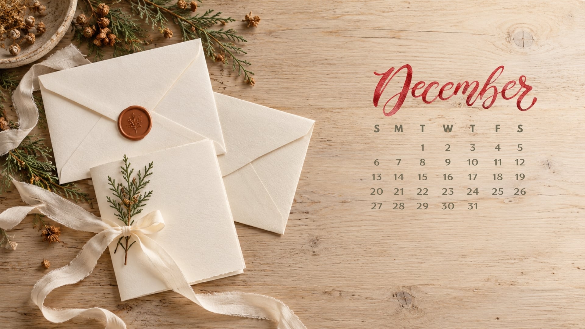 December 2026 desktop calendar with cream envelopes, ivory ribbon, a rust wax seal and a cedar sprig.