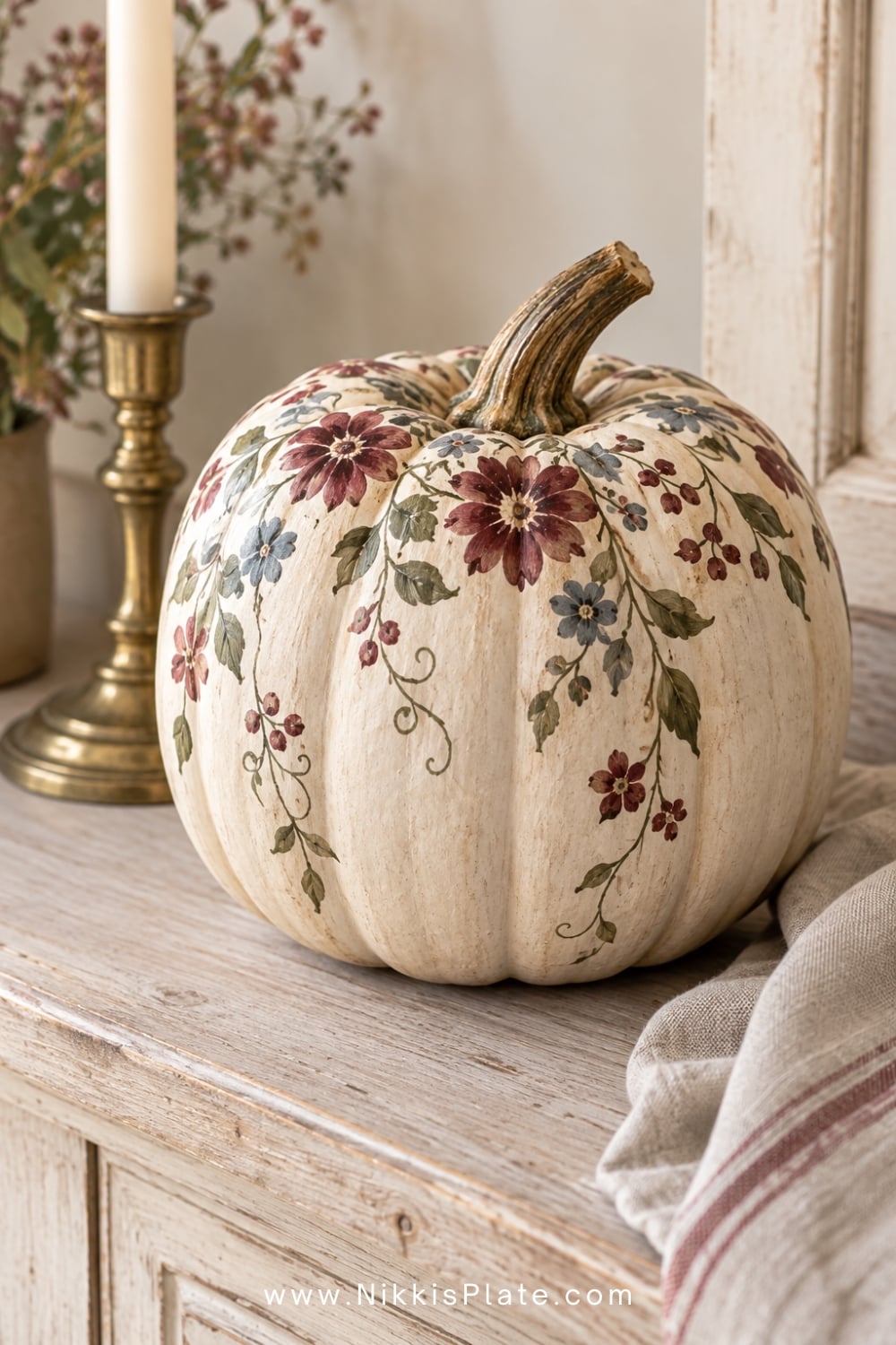 Cream pumpkin hand painted with burgundy, blue and olive folk flowers.