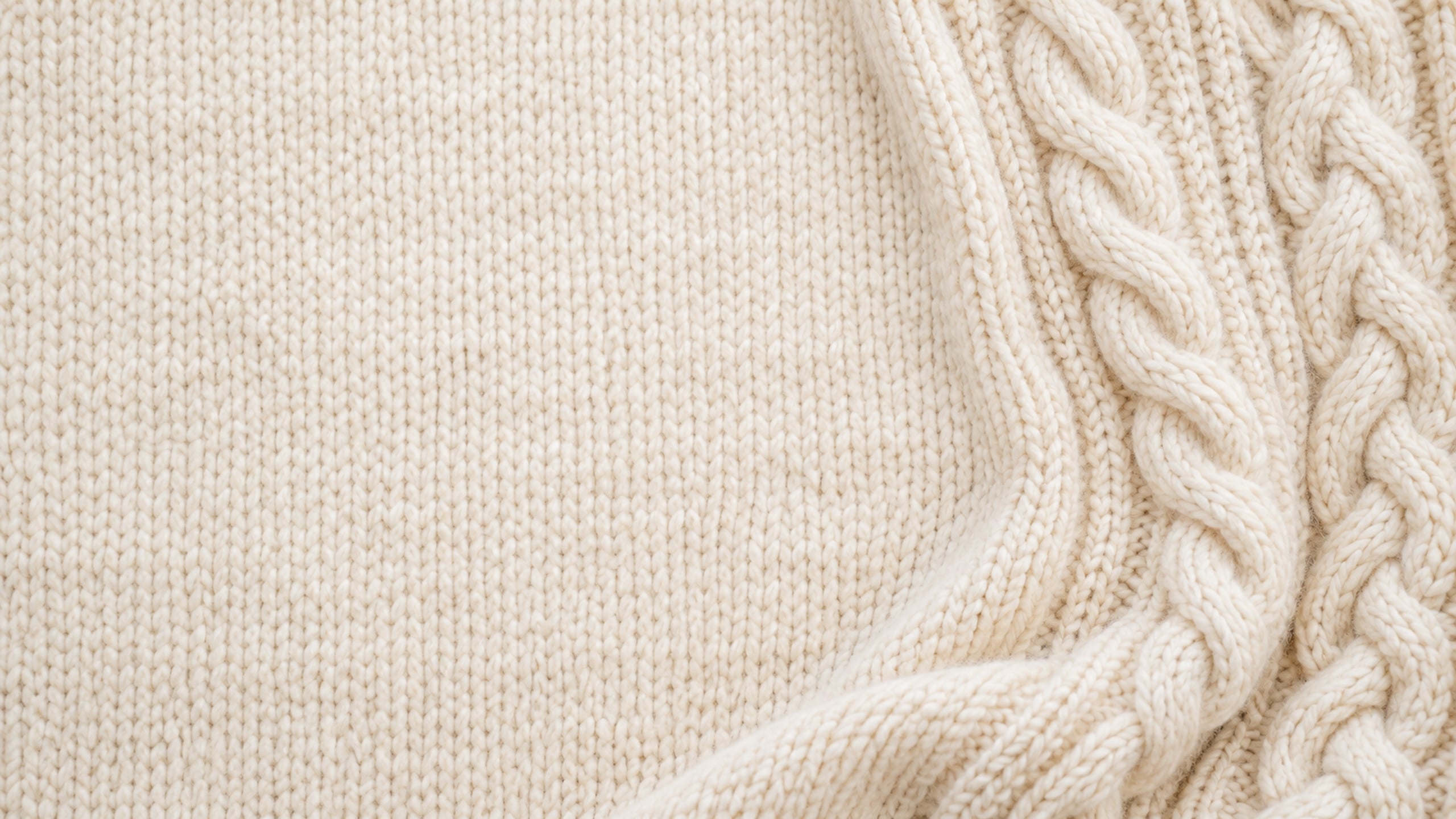Soft cream knitted fabric with a subtle cable pattern along the right edge.
