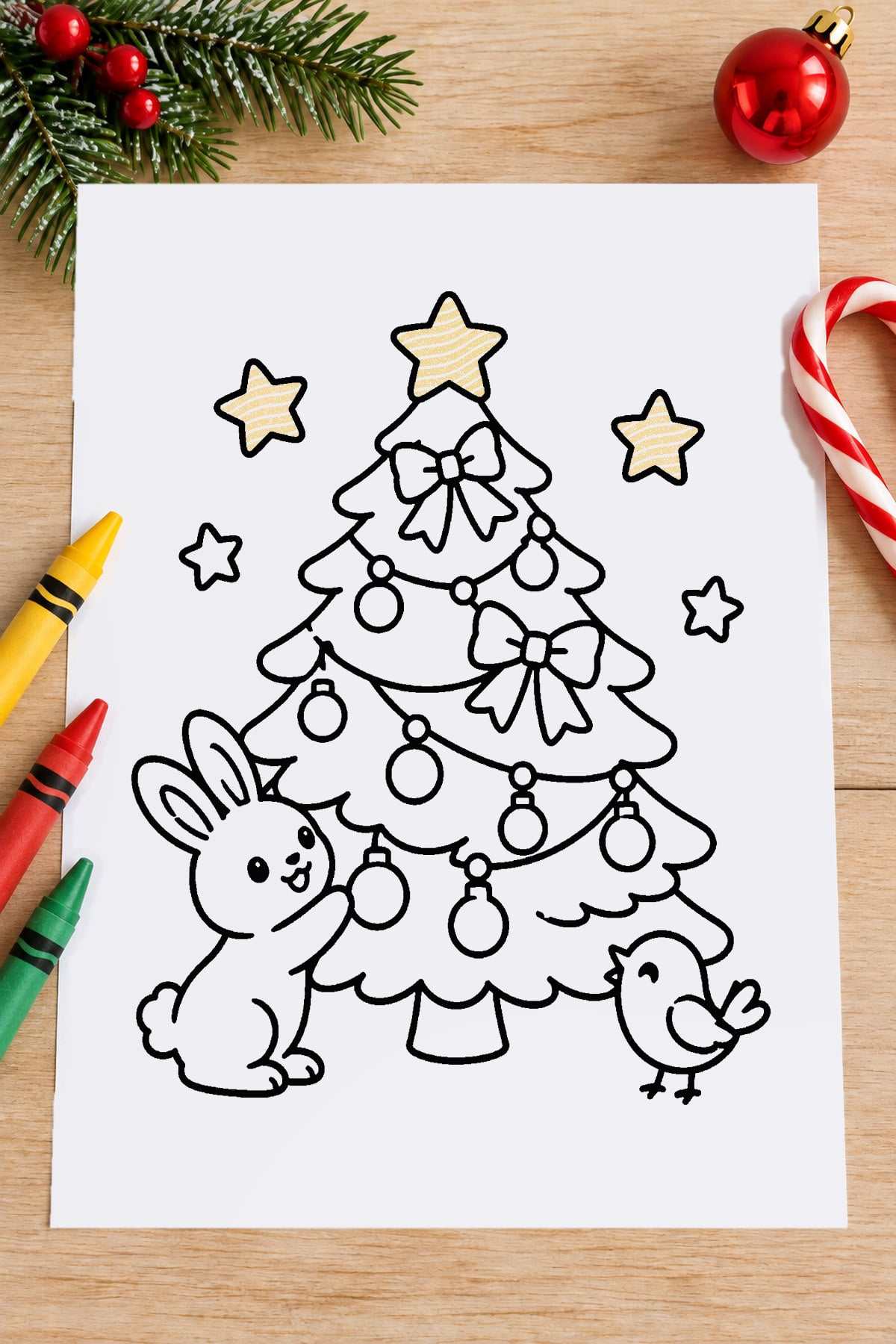 Woodland Christmas tree coloring page featuring a cute bunny, little bird, bows, and ornaments on a festive table with crayons.