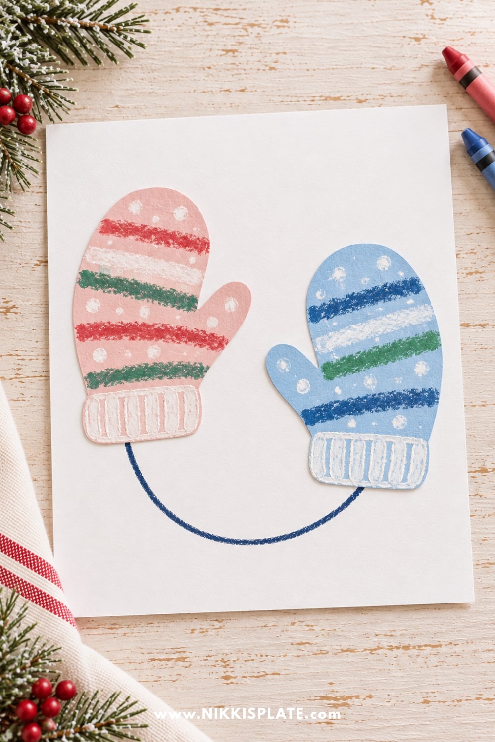 Two colorful paper Christmas mittens in pink and blue, decorated with festive stripes and snow dots and connected by a drawn string.