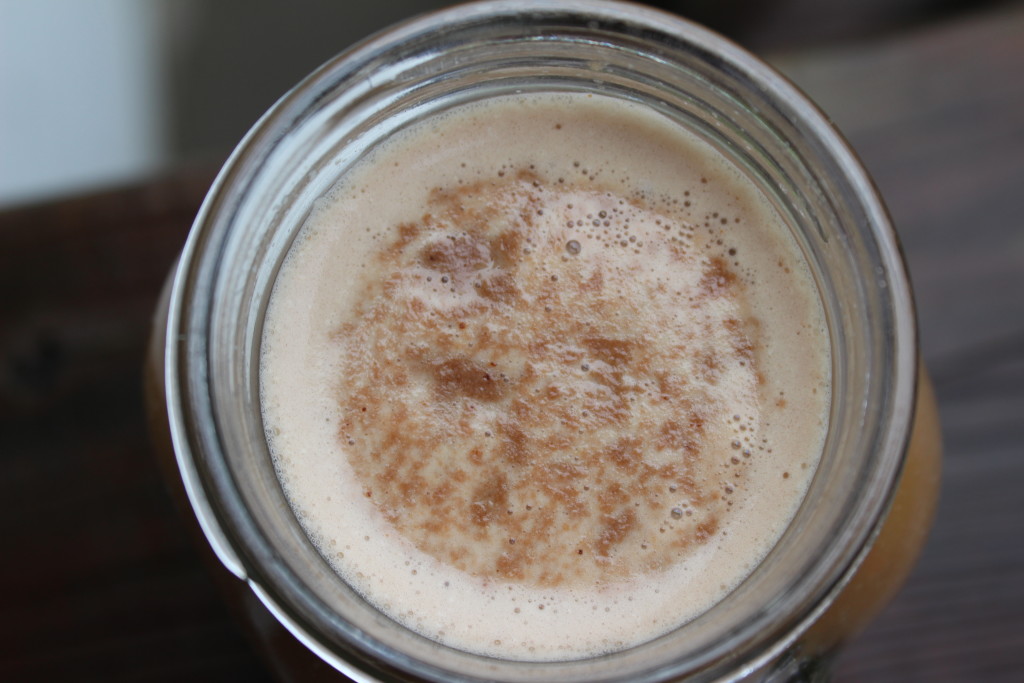 looking down on a mug of protein coffee topped with dairy free frothed toppings