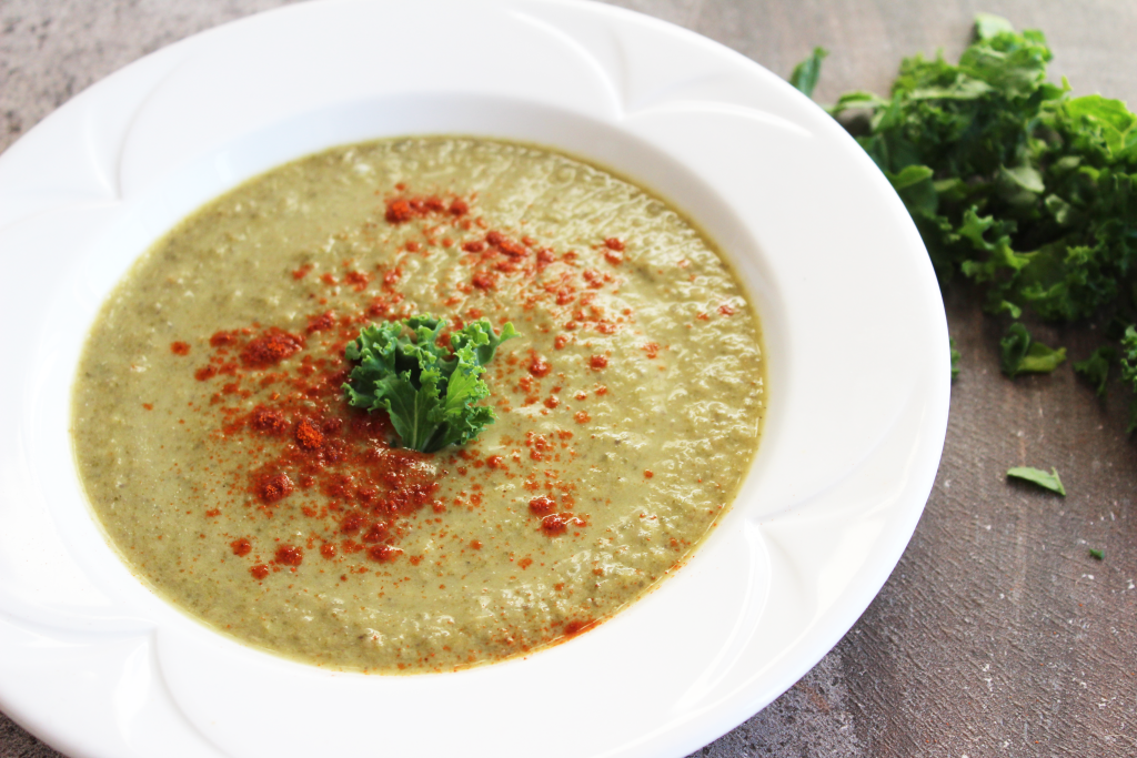 Round bowl of spicy kale soup recipe with fresh kale and cayenne pepper. Green leafy kale chopped.Base of potato and vegetable broth. Vegan, dairy free and gluten free. || Nikki's Plate