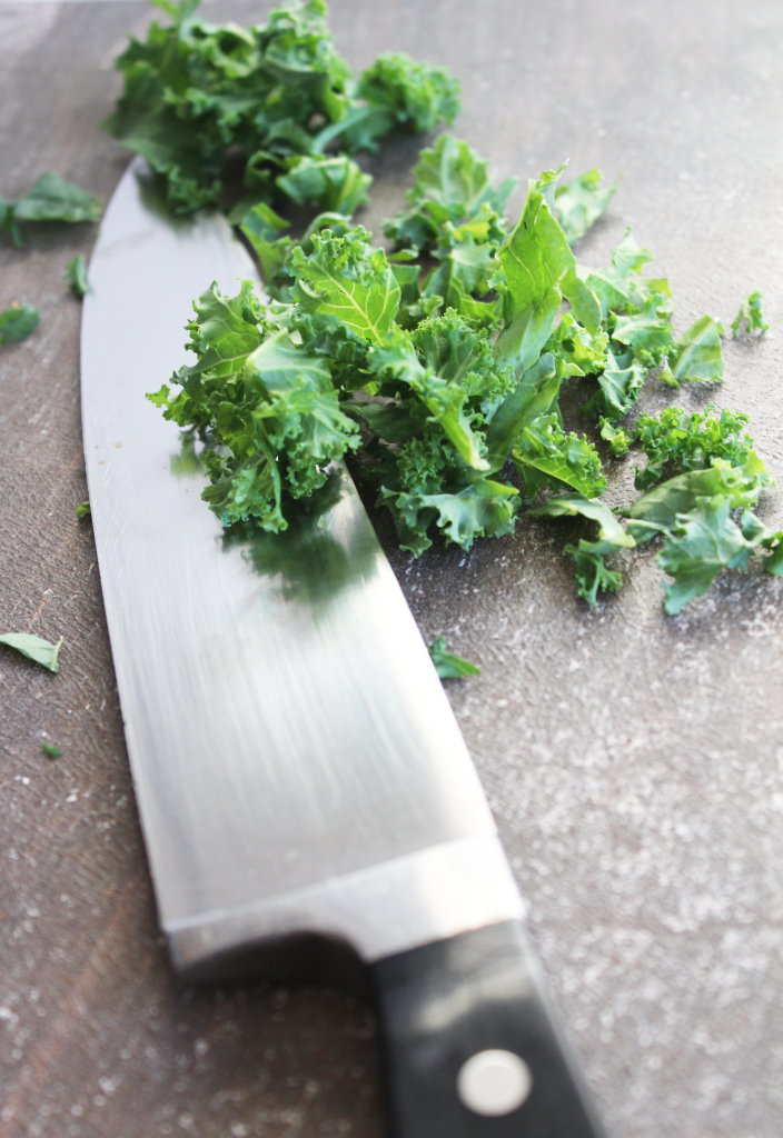 knife chopping green leafy kale for spicy kale soup recipe