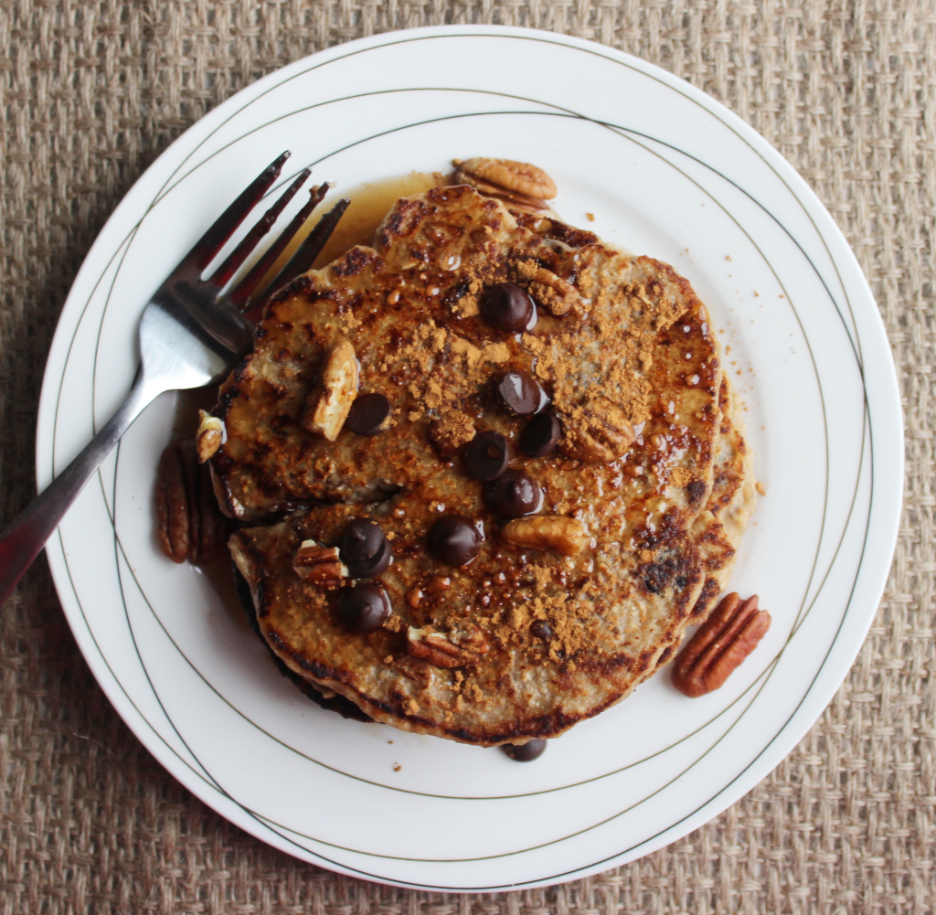 Peanut butter and pecan pancakes topped with chopped pecans, chocolate chips, and deliciously sweet syrup