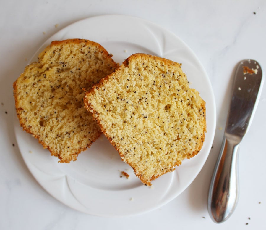 two pieces of Lemon Poppy seed Loaf on plate, small butter knife beside- Vegan and Gluten Free