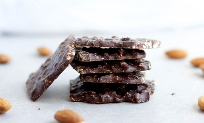 Stacked pieces of Salted Almond Dark Chocolate Bark; This guilt free salted almond and dark chocolate bark is the perfect dessert after dinner. Completely gluten free, dairy free and vegan! || Nikki's Plate