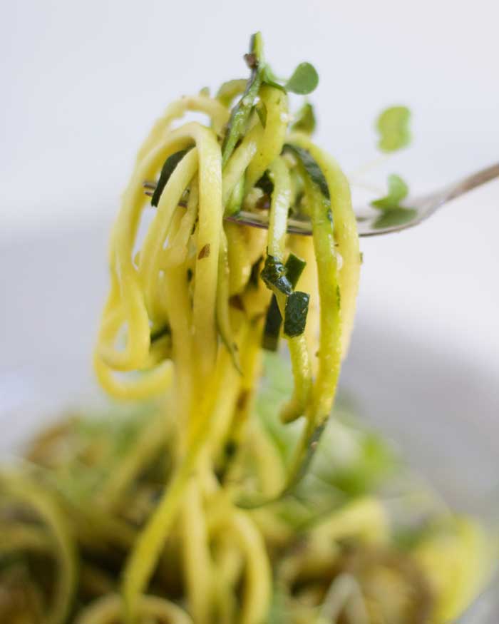 Tender and fresh zucchini noodles covered in a homemade spicy jalapeno pesto