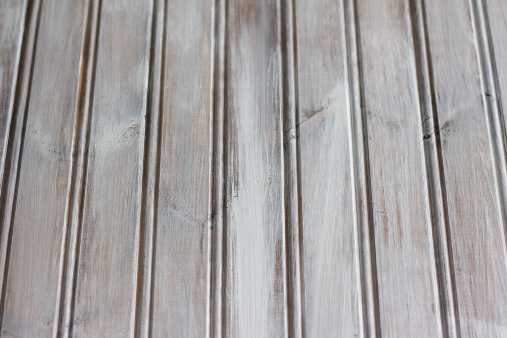 When whitewashing wood, you need to add a light layer of white paint with a few spots of more coverage