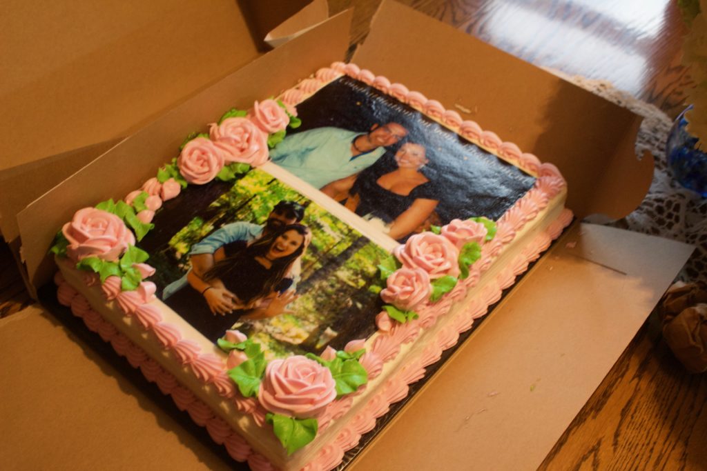 The lovely cake for Nikki and Dylan's engagement party featured two pictures of the couple and pink roses