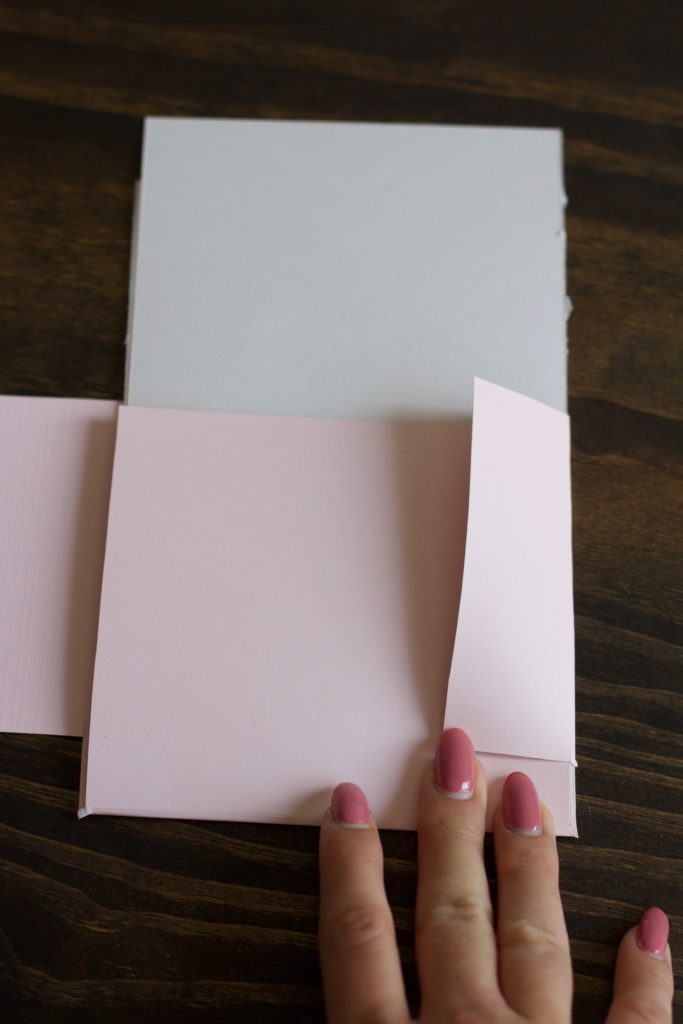 Folding pink cardstock to make a small folder to hold my bridesmaid proposal info cards