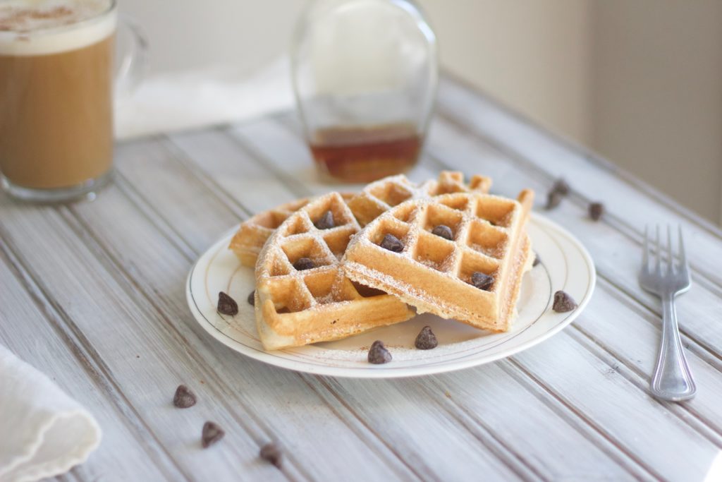 Homemade dairy free waffles topped with chocolate chips and dusted with powdered sugar