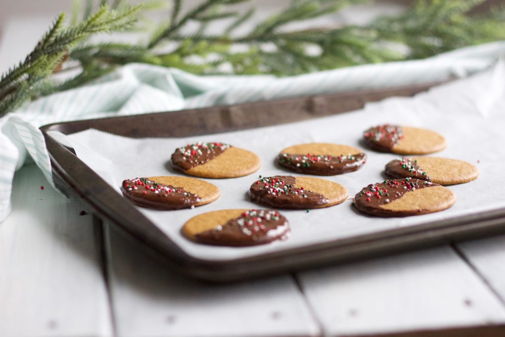 Gluten Free Chocolate Dipped Gingersnaps || a tray cooling round gingersnap cookies coated with dark chocolate with green and red sprinkles! || Nikki's Plate by Nikki Bahan