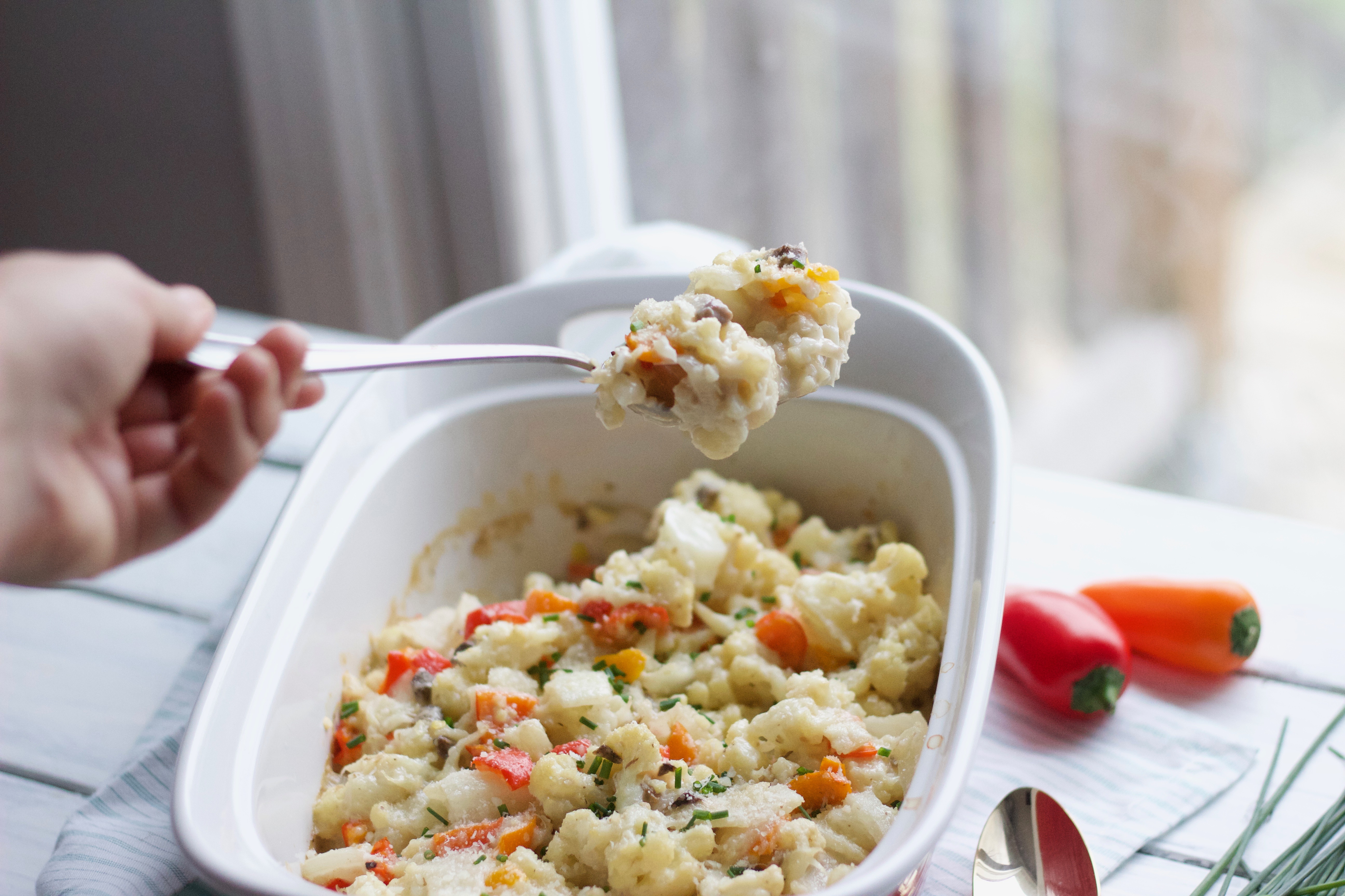 Utensil lifting up Creamy Cauliflower Bake with Tribelli Peppers from the casserole dish || Gluten free, dairy free, vegan - Nikki's Plate www.nikkisplate.com