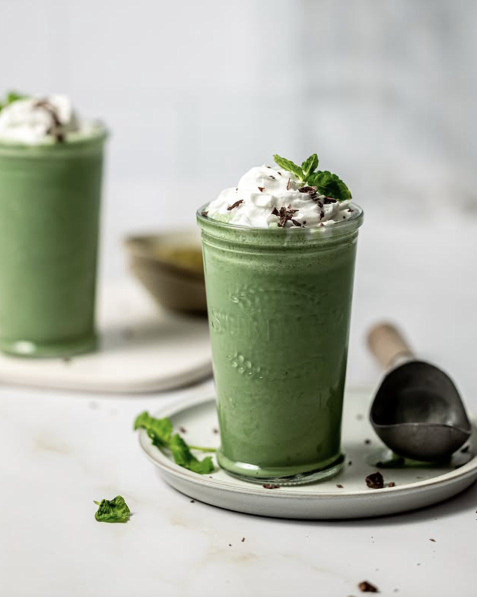 Healthy St Patrick's Day mint chocolate smoothie topped with whipped cream and chocolate shavings