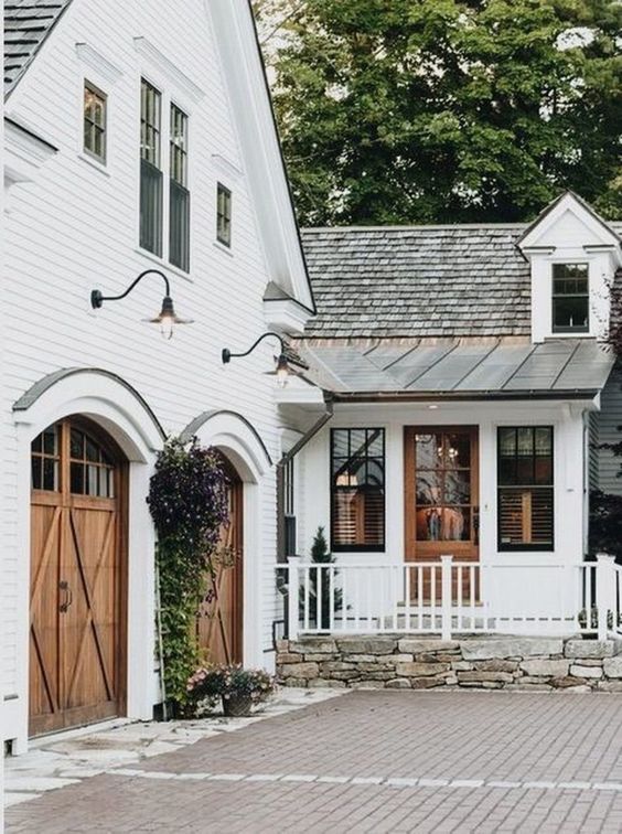 The barn door style garage doors on this farmhouse style home is a dream home must have!