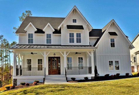 This farmhouse style home is so classic and clean with a mostly white exterior and black trim accents