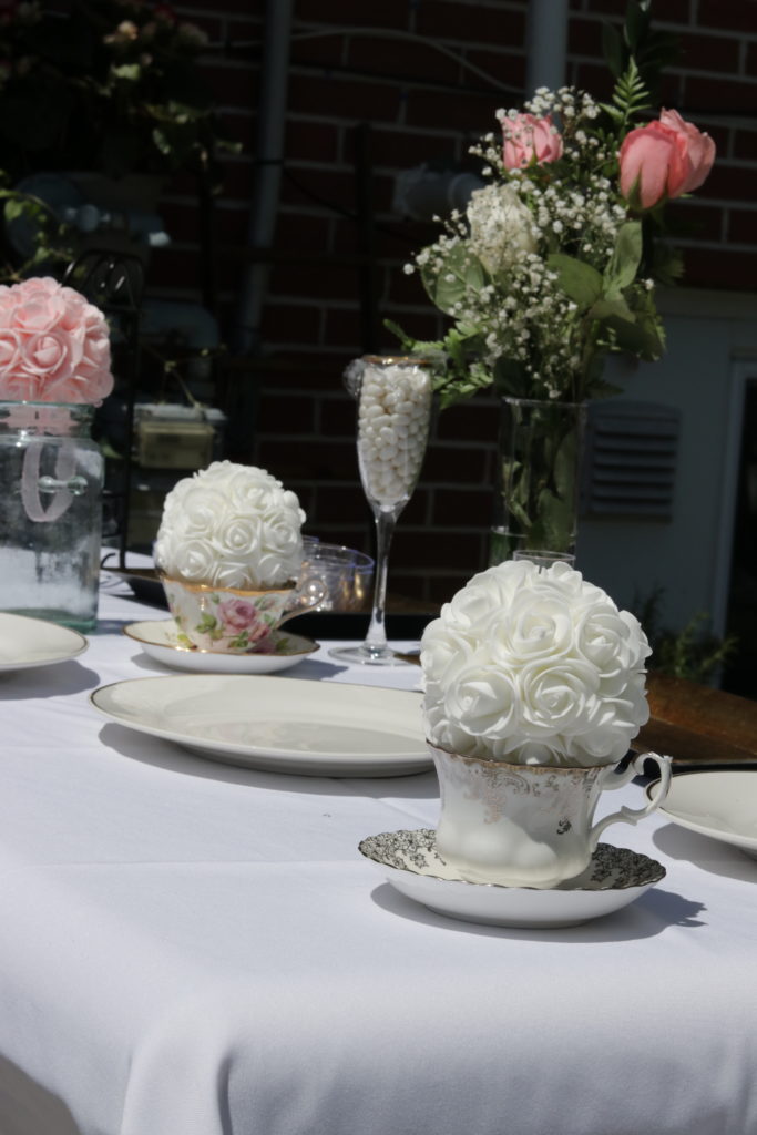 Gorgeous white and blush pink roses in vintage tea cups were the perfect centerpieces at my outdoor bridal shower