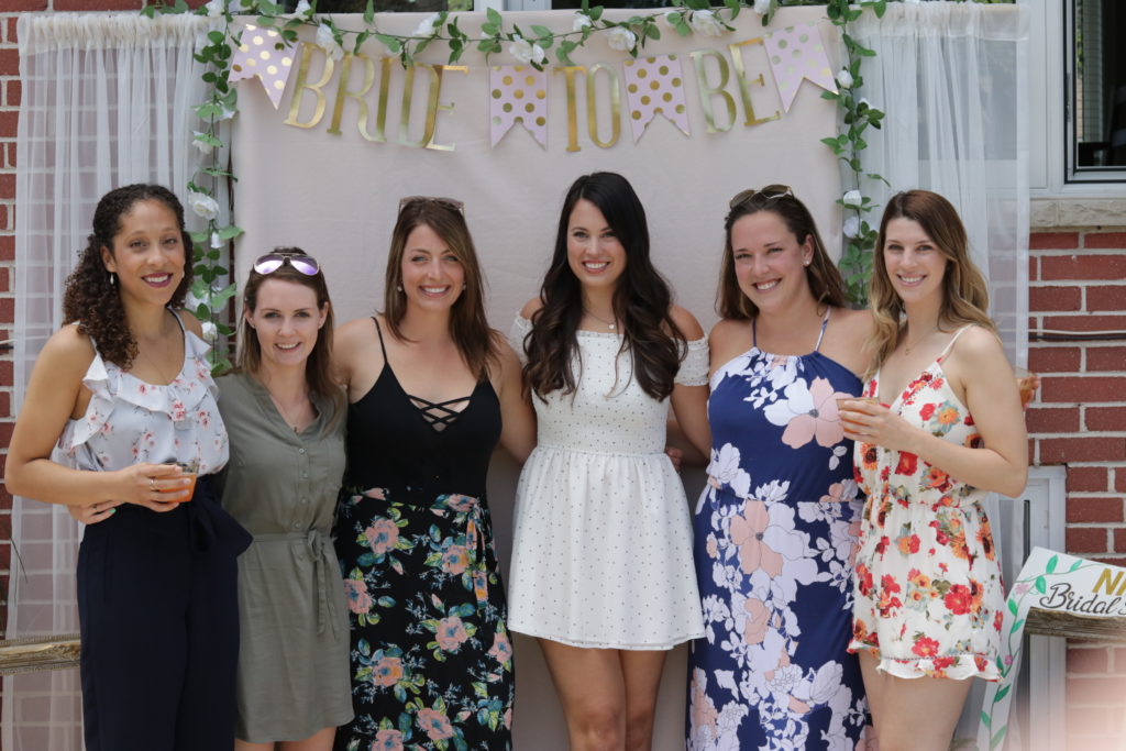 Nikki and her bridal party in front of the DIY bridal shower backdrop