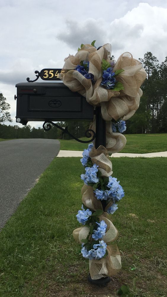 This elegant Christmas mailbox is decorated with lush burlap ribbon and fresh blue flowers