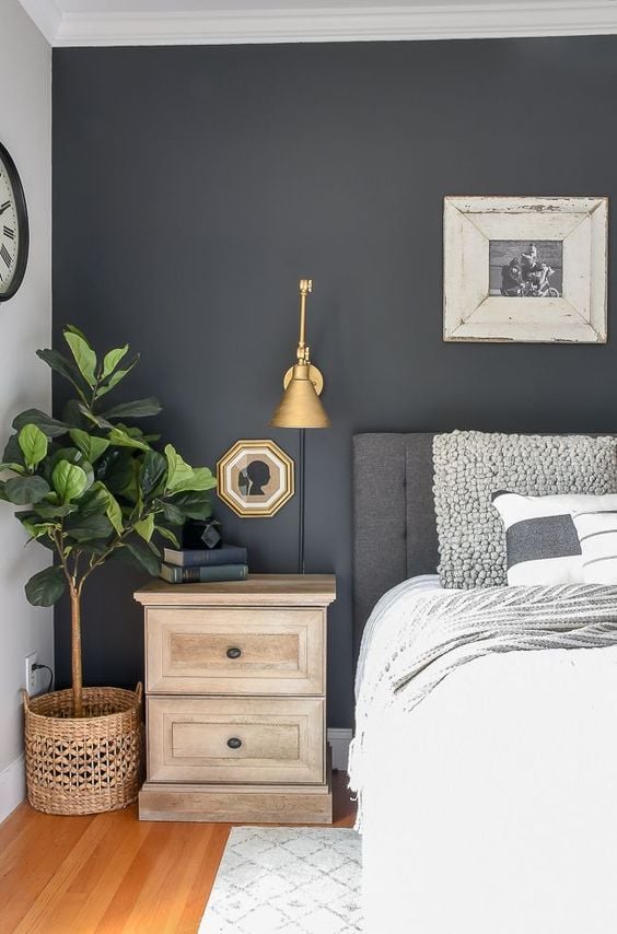 The dark grey accent wall in this master bedroom is echoed in grey linens and decor.