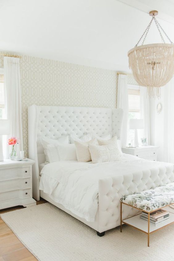 I love the subtle femininity of this master bedroom. The patterned wallpaper, upholstered headboard, and crystal light fixture are all great features