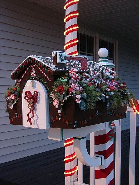 This Christmas mailbox is decorated like a gingerbread house, complete with candy pieces, frosting snow, and a candy cane pole