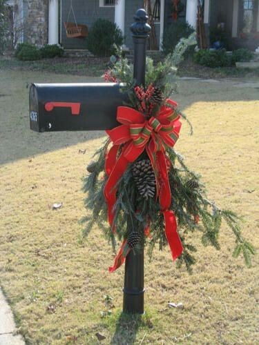 This Christmas mailbox has pine tree leaves complete with snowy pine cones and a large red and green plaid bow