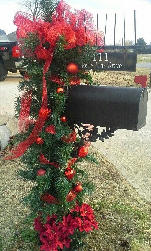 This Christmas mailbox is decked from top to bottom with fresh balsam branches, bright red ornaments and a big red bow