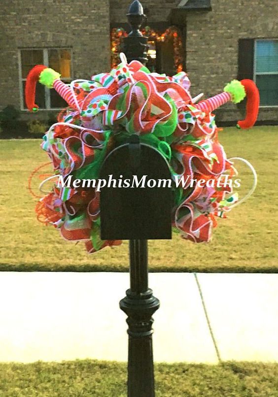 This whimsical Christmas mailbox is covered with colorful ribbon and topped with upside down elf legs!