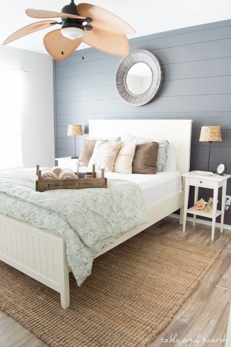 I love the tropical vibe of this master bedroom. The shiplap accent wall, and the large panel fan are statement features