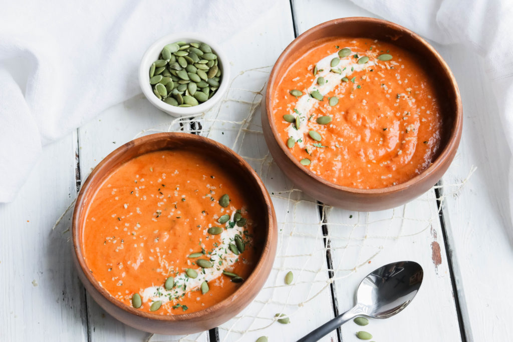 Horizontal view of two wood bowls with Spiced Pumpkin Soup; Warm roasted pumpkin pureed soup with a kick of spicy undertones. Fall/autumn comfort food! {Healthy Vegan, Gluten Free, Refined Sugar Free, Dairy Free} 