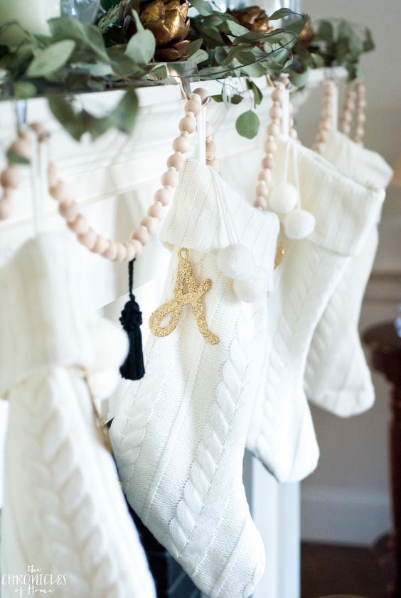 I love these white knit stockings wkith gold letters, hung on a simple green and gold Christmas mantel 