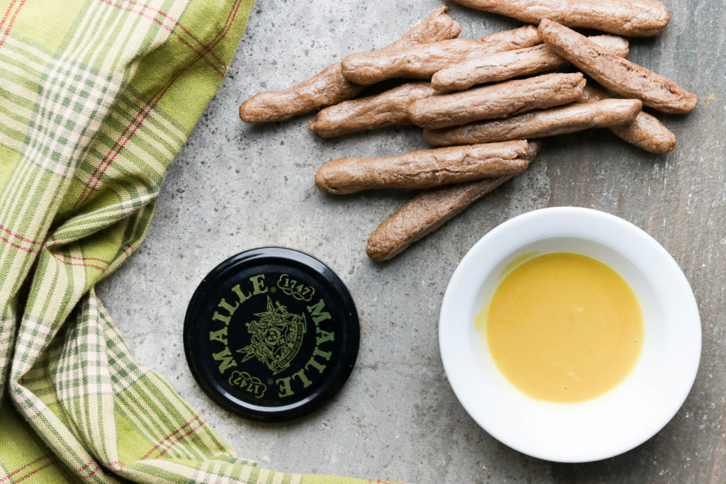 Homemade vegan pretzel sticks paired with a delicious maple mustard dip