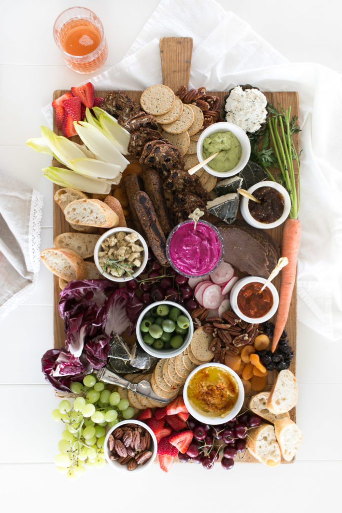 this vegan charcuterie board is packed with color from fresh fruits and veggies, along with plenty of dips and bread